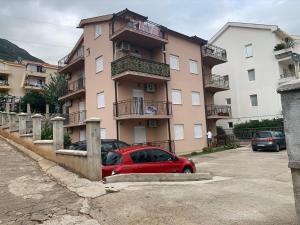 a red car parked in front of a building at Cv apartment in Herceg-Novi +4 photos
