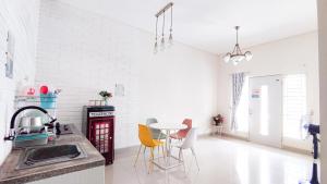 a kitchen with a sink and a table with chairs at Surabaya Homey near Juanda Airport Syariah in Sedati