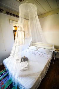 a bedroom with a bed with a mosquito net at Grape Island Bozcaada Guest House in Canakkale