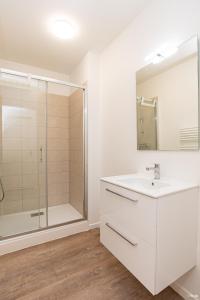 baño blanco con ducha y lavamanos en LE DUPLEX - T6 COEUR DE ViLLE, en Agen