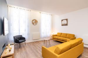 阿讓的住宿－LE DUPLEX - T6 COEUR DE ViLLE，客厅配有黄色的沙发和桌子