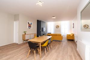 阿讓的住宿－LE DUPLEX - T6 COEUR DE ViLLE，用餐室以及带桌椅的起居室。