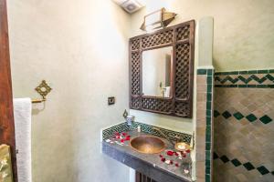 a bathroom with a sink and a mirror at Riad Jardin Chrifa in Fez