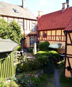 a woman sitting at a table in front of a house at Anno 1793 Sekelgården in Ystad