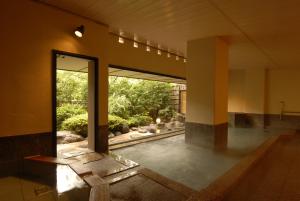 an empty room with a large window and a patio at Marukyu Ryokan in Izu