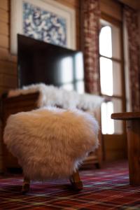 a white furry ottoman in a room with a piano at Appartement 5* au cœur de la station Arc 1950 in Arc 1950