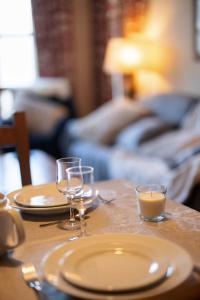 a wooden table with two plates and glasses on it at Appartement 5* au cœur de la station Arc 1950 in Arc 1950