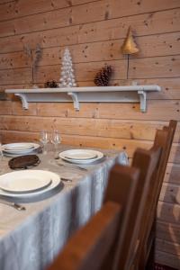 a table with plates and wine glasses on a wooden wall at Appartement 5* au cœur de la station Arc 1950 in Arc 1950