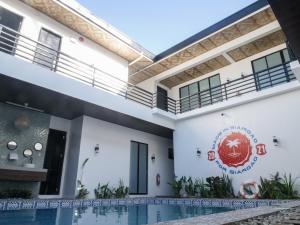 a house with a swimming pool in front of it at Siargao Bed and Brewery in General Luna