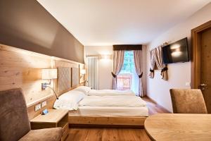 ein Hotelzimmer mit einem Bett und einem Fenster in der Unterkunft Hotel Crozzon in Madonna di Campiglio