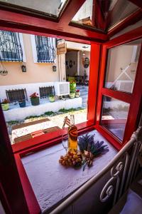 una ventana roja con una mesa con fruta y una botella de aceite en Grape Island Bozcaada Guest House, en Canakkale