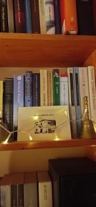 een plank gevuld met boeken op een boekenplank bij CASA BARTOLACCI COZY APARTMENT (NEAR FLORENCE CITY CENTER) in Bivigliano