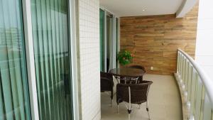 a balcony with a table and chairs on it at Dubai residência in Cabo Frio +26 photos