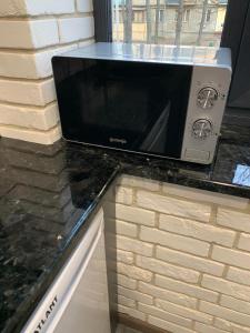 a microwave sitting on top of a counter at Уютная квартира возле метро 23 Августа in Kharkiv