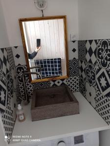 una persona que toma una foto de un espejo de baño en Le Clair centre ville, en Langon
