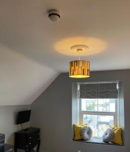 a window seat with yellow pillows and a chandelier at The White House Hotel in Newquay