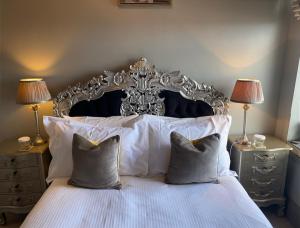 a bedroom with a bed with white sheets and pillows at The White House Hotel in Newquay