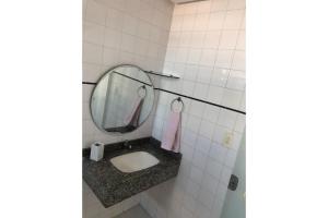 La salle de bains est pourvue d'un lavabo et d'un miroir. dans l'établissement Excelente Apartamento em Madre de Deus, à Madre de Deus