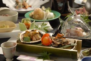 una mesa con platos de comida en una mesa en Marukyu Ryokan en Izu