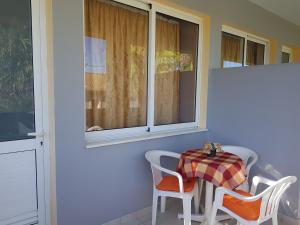 a table and chairs in a room with a window at Asteraki ApartHotel in Gouvia