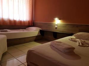 a hotel room with two beds and a window at Asteraki ApartHotel in Gouvia