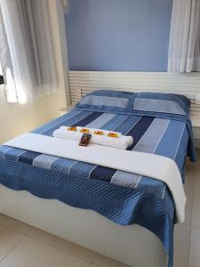 a bedroom with two beds with blue and white sheets at Guarajuba Paraíso dos Coqueiros in Guarajuba