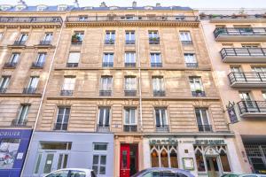 パリにあるNEW Eiffel Tour ! Splendid Apartments in the Heart of Parisの前に車が駐車されている大きな建物