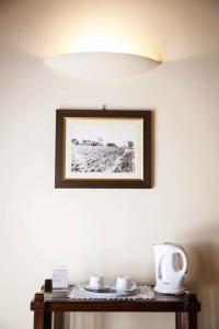 una foto en una pared con dos tazas en una mesa en Agriturismo Il Quarto, en Manciano