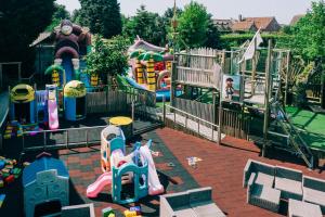 een park met een speeltuin met een glijbaan bij Hotel De Kalvaar in Ninove