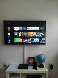 una TV a schermo piatto su un muro sopra un tavolo di Meridian a Zagabria