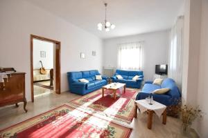 uma sala de estar com sofás azuis e um tapete em Relaxing experiences near Ancient Olympia em Archea Pissa