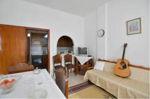 uma sala de estar com um sofá e uma guitarra na parede em Relaxing experiences near Ancient Olympia em Archea Pissa
