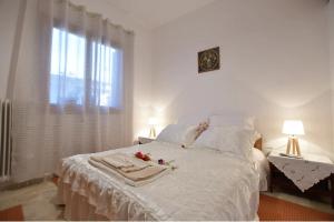Un dormitorio con una cama blanca con flores. en Relaxing experiences near Ancient Olympia, en Archea Pissa