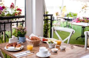una mesa de madera con productos para el desayuno en Olive Arena Boutique&Business Hotel-By Ran Hotels en Nahariyya