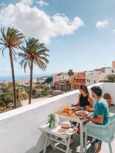 two people sitting at a table on a balcony at Villa Nestor in Ingenio