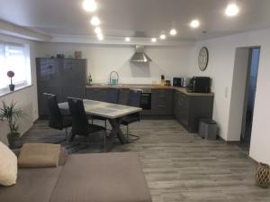 a kitchen with a table and chairs in a room at Ferienwohnung Nachtweide in Wadgassen +7 photos
