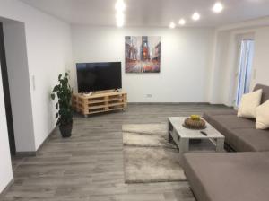 a living room with a couch and a flat screen tv at Ferienwohnung Nachtweide in Wadgassen