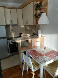 una piccola cucina con tavolo e una sala da pranzo di ANKA apartman a Smederevo