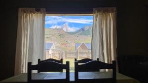 1 dormitorio con ventana y vistas a la montaña en Concolor en El Chaltén