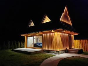 a house with a lit up facade at night at Górska Baja Premium House in Witów