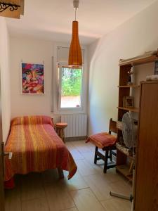 科爾百托的住宿－Casa acogedora al pie de Montserrat，一间卧室设有一张床、一个窗口和一把椅子