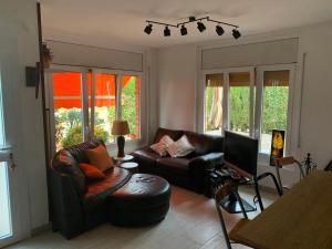 a living room with a couch and a tv at Casa acogedora al pie de Montserrat in Collbató