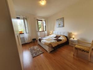 Schlafzimmer mit einem Bett und Holzboden in der Unterkunft L'Antico Granaio in Negrar