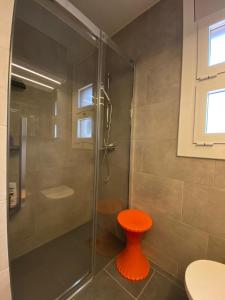 a shower with an orange stool in a bathroom at Casa acogedora al pie de Montserrat in Collbató