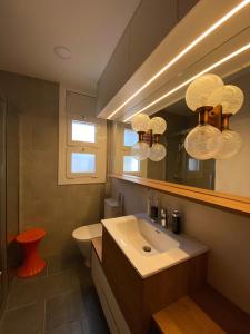 a bathroom with a sink and a toilet and a mirror at Casa acogedora al pie de Montserrat in Collbató