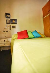 a bedroom with a bed with colorful pillows on it at The Blue Room in Mendoza