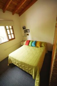 a bedroom with a bed with colorful pillows on it at The Blue Room in Mendoza
