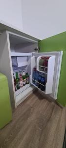 a small refrigerator with its door open in a room at Candy Pensiune&Restaurant in Dumbrava Roşie