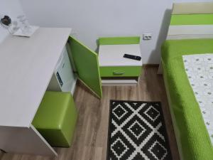 a bedroom with green and white furniture and a desk at Candy Pensiune&Restaurant in Dumbrava Roşie