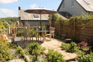 a patio with a table and chairs and an umbrella at Sky Cottage in Fowey